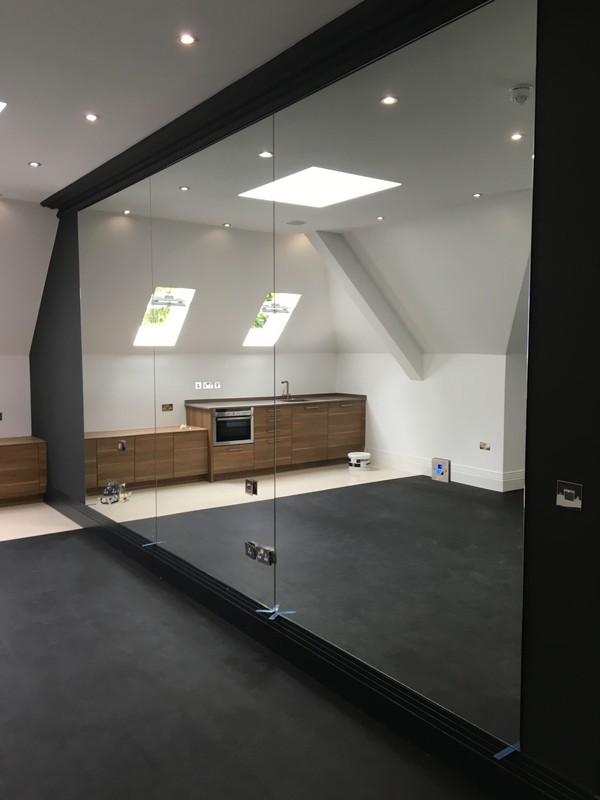 Frameless glass partition in loft conversion by Hounslow glaziers