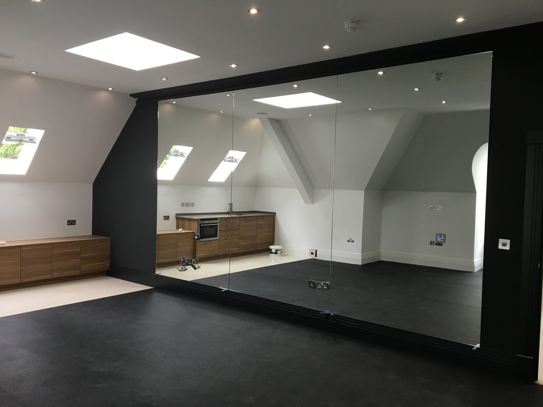 Frameless glass wall dividing loft conversion in Hounslow
